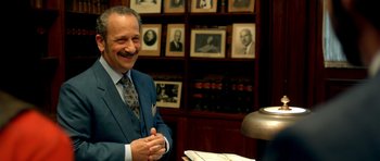 Movie still from “The Secret in Their Eyes” (2009), directed by Juan José Campanella – A man wearing a suit and tie in a room; Medium shot, Over the shoulder angle