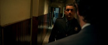 Movie still from “The Secret in Their Eyes” (2009), directed by Juan José Campanella – A man in a uniform is walking down a hallway; Medium shot, Over the shoulder angle