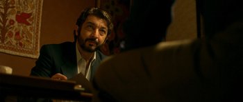 Movie still from “The Secret in Their Eyes” (2009), directed by Juan José Campanella – A person wearing headphones looking at the camera; Close Up shot, Over the shoulder angle