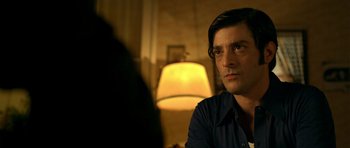 Movie still from “The Secret in Their Eyes” (2009), directed by Juan José Campanella – A man sitting in front of a lamp in a dimly - lit room; Close Up shot, Over the shoulder angle