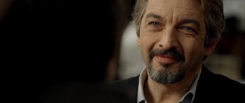 Movie still from “The Secret in Their Eyes” (2009), directed by Juan José Campanella – A person wearing a suit and beard; Close Up shot, Over the shoulder angle