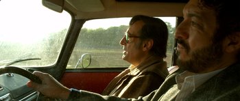 Movie still from “The Secret in Their Eyes” (2009), directed by Juan José Campanella – A man sitting in the driver's seat of a car; Medium shot, Low angle