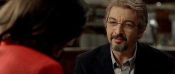 Movie still from “The Secret in Their Eyes” (2009), directed by Juan José Campanella – An older man wearing glasses and a suit; Close Up shot, Over the shoulder angle