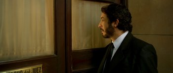 Movie still from “The Secret in Their Eyes” (2009), directed by Juan José Campanella – A man in a suit looking out of a window; Close Up shot, Low angle