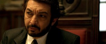Movie still from “The Secret in Their Eyes” (2009), directed by Juan José Campanella – A person wearing a suit and tie; Close Up shot, Over the shoulder angle