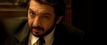 Movie still from “The Secret in Their Eyes” (2009), directed by Juan José Campanella – A person wearing a suit and tie; Close Up shot, Over the shoulder angle