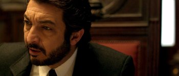 Movie still from “The Secret in Their Eyes” (2009), directed by Juan José Campanella – A person wearing a suit and tie; Close Up shot, Over the shoulder angle