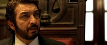 Movie still from “The Secret in Their Eyes” (2009), directed by Juan José Campanella – A person wearing a suit and tie; Close Up shot, Over the shoulder angle