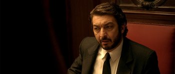 Movie still from “The Secret in Their Eyes” (2009), directed by Juan José Campanella – A person wearing a suit and tie; Close Up shot, High angle