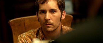 Movie still from “The Secret in Their Eyes” (2009), directed by Juan José Campanella – A person sitting in a chair; Close Up shot, Over the shoulder angle