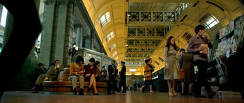 Movie still from “The Secret in Their Eyes” (2009), directed by Juan José Campanella – A group of people sitting on a bench in a building; Wide shot, Low angle