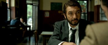 Movie still from “The Secret in Their Eyes” (2009), directed by Juan José Campanella – A person wearing a suit and tie; Close Up shot, Over the shoulder angle