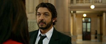 Movie still from “The Secret in Their Eyes” (2009), directed by Juan José Campanella – A person wearing a suit and tie; Close Up shot, Over the shoulder angle