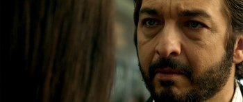 Movie still from “The Secret in Their Eyes” (2009), directed by Juan José Campanella – A man with a beard looking at the camera; Extreme Close Up shot, Over the shoulder angle