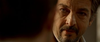 Movie still from “The Secret in Their Eyes” (2009), directed by Juan José Campanella – A man with a beard looking at the camera; Extreme Close Up shot, Over the shoulder angle