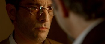Movie still from “The Secret in Their Eyes” (2009), directed by Juan José Campanella – A person wearing glasses; Extreme Close Up shot, Over the shoulder angle