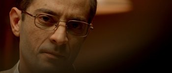 Movie still from “The Secret in Their Eyes” (2009), directed by Juan José Campanella – A person wearing glasses; Close Up shot, Low angle