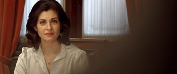 Movie still from “The Secret in Their Eyes” (2009), directed by Juan José Campanella – A woman wearing a white shirt is sitting in a chair; Close Up shot, Over the shoulder angle