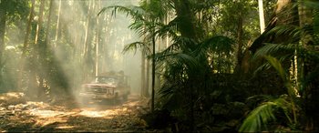 Movie still from “The Shallows” (2016), directed by Jaume Collet-Serra – A truck driving down a dirt road through a forest; Extreme Wide shot, High angle
