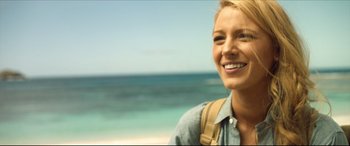 Movie still from “The Shallows” (2016), directed by Jaume Collet-Serra – A woman smiling at the camera on the beach; Close Up shot, Over the shoulder angle