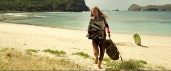 Movie still from “The Shallows” (2016), directed by Jaume Collet-Serra – A beautiful young woman walking on the beach with a suitcase; Wide shot, Low angle