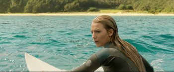 Movie still from “The Shallows” (2016), directed by Jaume Collet-Serra – A woman in a wetsuit sitting on a surfboard in the water; Close Up shot, Over the shoulder angle