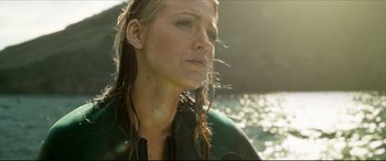 Movie still from “The Shallows” (2016), directed by Jaume Collet-Serra – A person wearing ear buds near a body of water; Close Up shot, Low angle