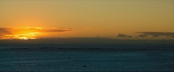 Movie still from “The Shallows” (2016), directed by Jaume Collet-Serra – A body of water with a person in the water at sunset; Extreme Wide shot, Low angle