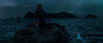 Movie still from “The Shallows” (2016), directed by Jaume Collet-Serra – A woman sitting on top of a rock near the ocean; Wide shot, Low angle