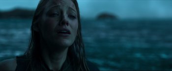 Movie still from “The Shallows” (2016), directed by Jaume Collet-Serra – A woman with long brown hair is crying in front of a body of water; Close Up shot, Low angle