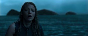 Movie still from “The Shallows” (2016), directed by Jaume Collet-Serra – A woman standing in front of a body of water at night; Close Up shot, Low angle