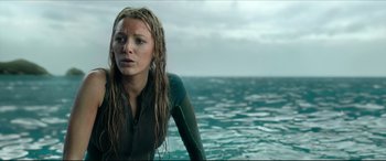 Movie still from “The Shallows” (2016), directed by Jaume Collet-Serra – A woman in a wetsuit standing in the water; Close Up shot, Low angle