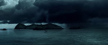 Movie still from “The Shallows” (2016), directed by Jaume Collet-Serra – Dark storm clouds loom over a body of water; Extreme Wide shot, High angle