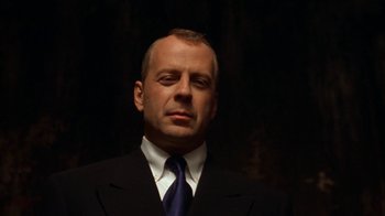 Movie still from “The Siege” (1998), directed by Edward Zwick – A person wearing a suit and tie; Close Up shot, Low angle