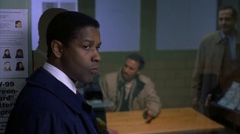 Movie still from “The Siege” (1998), directed by Edward Zwick – A man standing in front of another man in front of a table; Close Up shot, Over the shoulder angle