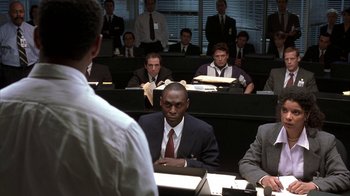 Movie still from “The Siege” (1998), directed by Edward Zwick – A group of men sitting in front of each other in a room; Medium shot, Over the shoulder angle