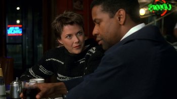 Movie still from “The Siege” (1998), directed by Edward Zwick – A woman sitting next to a man at a table; Medium shot, Over the shoulder angle