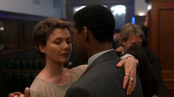 Movie still from “The Siege” (1998), directed by Edward Zwick – A man and a woman dancing together in a room; Close Up shot, Over the shoulder angle