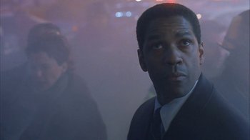 Movie still from “The Siege” (1998), directed by Edward Zwick – A person wearing a suit and tie; Close Up shot, Low angle