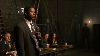 Movie still from “The Siege” (1998), directed by Edward Zwick – A man standing in front of two other people; Medium shot, Low angle