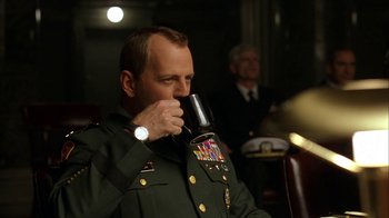 Movie still from “The Siege” (1998), directed by Edward Zwick – A man in a military uniform drinking a glass of red wine; Close Up shot, Low angle