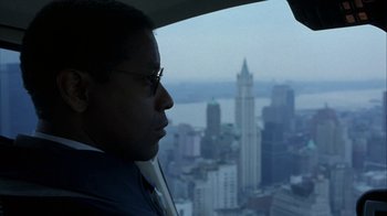 Movie still from “The Siege” (1998), directed by Edward Zwick – A man looking out of a helicopter window at a city skyline; Close Up shot, Over the shoulder angle
