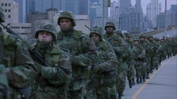 Movie still from “The Siege” (1998), directed by Edward Zwick – A group of men in military fatigues marching down a street; Wide shot, High angle