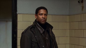 Movie still from “The Siege” (1998), directed by Edward Zwick – A man wearing a black jacket standing in a room; Close Up shot, Over the shoulder angle