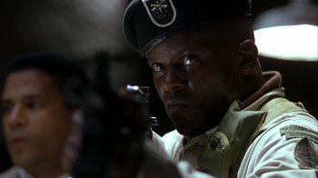 Movie still from “The Siege” (1998), directed by Edward Zwick – A man in a military uniform is holding a gun; Close Up shot, Low angle