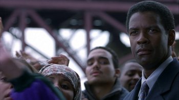 Movie still from “The Siege” (1998), directed by Edward Zwick – A group of people standing next to each other in a crowd; Close Up shot, Over the shoulder angle