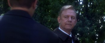 Movie still from “The Sisterhood of the Traveling Pants” (2005), directed by Ken Kwapis – A man in a suit and tie standing next to another man in a suit and tie; Close Up shot, Over the shoulder angle