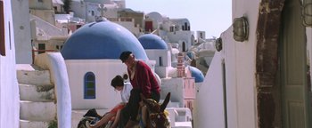 Movie still from “The Sisterhood of the Traveling Pants” (2005), directed by Ken Kwapis – A man sitting on top of a donkey next to a woman; Wide shot, High angle