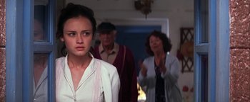 Movie still from “The Sisterhood of the Traveling Pants” (2005), directed by Ken Kwapis – A young woman standing next to an older man and woman; Medium shot, Over the shoulder angle