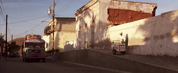 Movie still from “The Sisterhood of the Traveling Pants” (2005), directed by Ken Kwapis – A man riding on the back of a small truck; Extreme Wide shot, Low angle